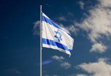 Netanyahu Faces Opposition Ahead of Israel’s 2026 Election Israeli flag fluttering under a bright blue sky.